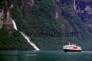 Mittlerweile in den Geirangerfjord eingeschwenkt passiert die Hurtigrute den Friaren Wasserfall. Kurz danach überholt der Schnelldampfer mit der Schiffssirene grüßend die Autofähre.